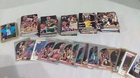 Several stacks of basketball cards laid out on a white surface showing different player images and card faces.