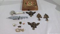 Lot showing brass cherub furniture ornaments, letter opener, cutter, pins, and cigar box