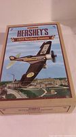 Box top featuring vintage style artwork and title of Hershey's 1932 Northrop Gamma airplane collectible bank.