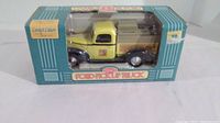 Front view of boxed yellow and black 1940 Ford pickup truck 1/25 scale model in original Home Hardware packaging.