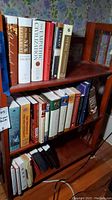 Books on shelves show a variety of theological and religious texts including a large Archaeological Study Bible and other titles on Christianity and Judaism.