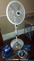Photo showing the Lot items including white Lasko floor fan, blue Breg Polar Game Cube cooling knee therapy device, smaller brown portable fan, and a small blue fan component.