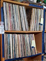 Photo showing two shelves filled with numerous international and Celtic vinyl record albums stored vertically in their sleeves.