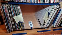 Shelf of vinyl record albums with label 'Easy Listening' showing album spines in paper sleeves with some visible wear.
