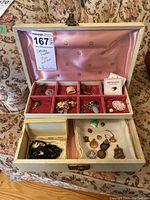 Full view of open jewelry box showing multiple sections of assorted costume jewelry items inside