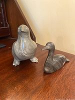 Two soapstone bird carvings displayed side by side showing shape and surface colors