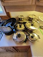 Full assortment of pots, pans, roasting pan and sieves on kitchen countertop