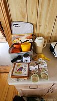 Lot items displayed on countertop with cooler bag open showing containers.