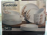 Box front showing Trudeau branding, porcelain dinnerware set with brown leaf pattern, total 24 pieces.