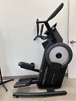 Side profile view of the elliptical trainer showing frame, pedals and handlebar design