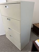 Four-drawer filing cabinet angled view showing color and overall condition.