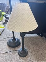 Photo showing the table lamp and floor lamp side by side, highlighting the matching off-white textured fabric shades and dark metal bases.