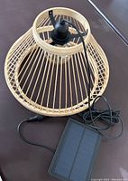Photo of the hanging bamboo framed lamp with attached cable and solar panel.