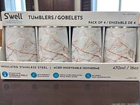Front view of boxed set of four S'well insulated stainless steel tumblers, 16oz, with white marble and rose gold veining design.