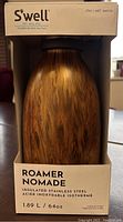 Front view of S'well Roamer water bottle in original packaging featuring wood print design.