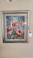 Framed painting with floral design featuring pink flowers and blue background.