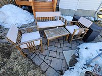 Full view of entire patio set on outdoor stone pavers with snow in background