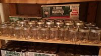 Photo of three boxes labeled Bernardin 12-500ml wide mouth canning jars and loose glass jars arranged above and below boxes with metal lids visible.