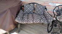 Cast metal loveseat on deck with seat and back cushions in place