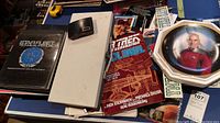 Photo showing Star Trek technical manuals and related books along with a remote control driving cover.