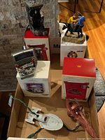 Wide shot of all ornaments and their original boxes, showing detailed Star Trek themed miniature scenes, ships, and characters.