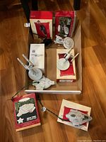 Overview photo showing six Hallmark Star Trek ornaments with original boxes inside a box on wooden floor.