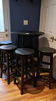 Full set front view showing round table and four matching stools against wall