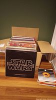Box of vinyl LPs with Star Wars and The Bangles covers visible, plus a stack of 7-inch singles