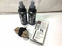 Front view showing two black spray bottles labeled M-Pro 7 Cleaner 118ml each, coiled Hoppe's bore snake, and Tasco base set in package with hex key and screws.