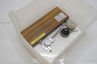 Photo of all Mitutoyo precision tools together in a plastic bin showing wooden gauge block set box and dial/digital gauges.