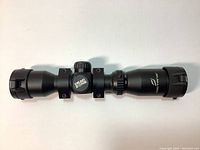 Side view of matte black Octane Dead Zone scope with logo visible on adjustment turret, showing full length with lens caps closed.