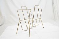 Full frontal view of the vintage brass magazine holder showing its symmetrical design and two compartments for storage.