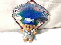 Front view of the Forest Troll figure with blue hair and Toronto Blue Jays uniform against the colorful cardboard backing with World Series logos and limited edition tags.