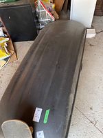 Closed black Yakima car roof storage box with modest wear on the exterior surface.