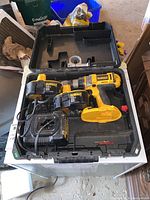 Open carrying case containing DeWalt 18V cordless drill, two batteries, and charger