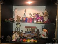 Assorted figurines and collectibles placed on shelves including animal figurines, decorative clocks, and toy trucks.