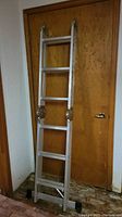 Front view of the ladder in a closed position showing aluminum rungs and rails.
