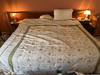 Front view of assembled teak platform king bed with headboard, mattress, and bedding.