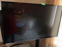 Front view of the LG TV showing reflective screen and LG logo on bezel.