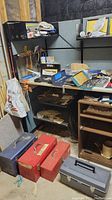 Overview of toolboxes and hand tools on shelving and table in basement