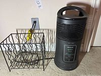 Metal wire rack and Honeywell Surround heater side by side on floor near outlet
