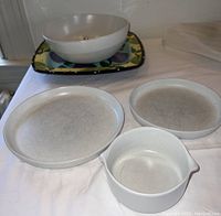 Photo showing two white ceramic dinner plates, one small white ceramic serving bowl, and the plum motif ceramic platter in the background