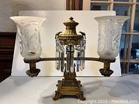 Front view of one complete lamp showing both frosted etched glass shades and hanging crystal prisms.