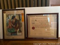 Photo showing two framed artworks side by side on floor; left is figurative painting and right is Mayflower document