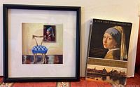 Photo of the signed framed lithograph and paperback book placed on a table, showing the art details and book cover.