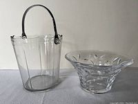 Glass ice bucket with hammered metal handle and ribbed vertical design, shown from side angle