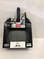 Frying pan in box showing Ballarini branding and Torino Granitium series name along with care and warranty details.