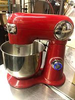Front side view of the red Cuisinart stand mixer with stainless steel bowl attached, speed control knob visible with blue light