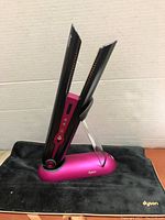 Dyson Corrale straightener on charging stand placed on black heat-resistant mat