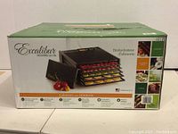 Box of Excalibur 5-tray food dehydrator showing product image and features.